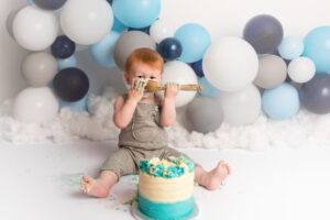 Baby boy tucking in to cake at his cake smash photo photo shoot in Aberdeen